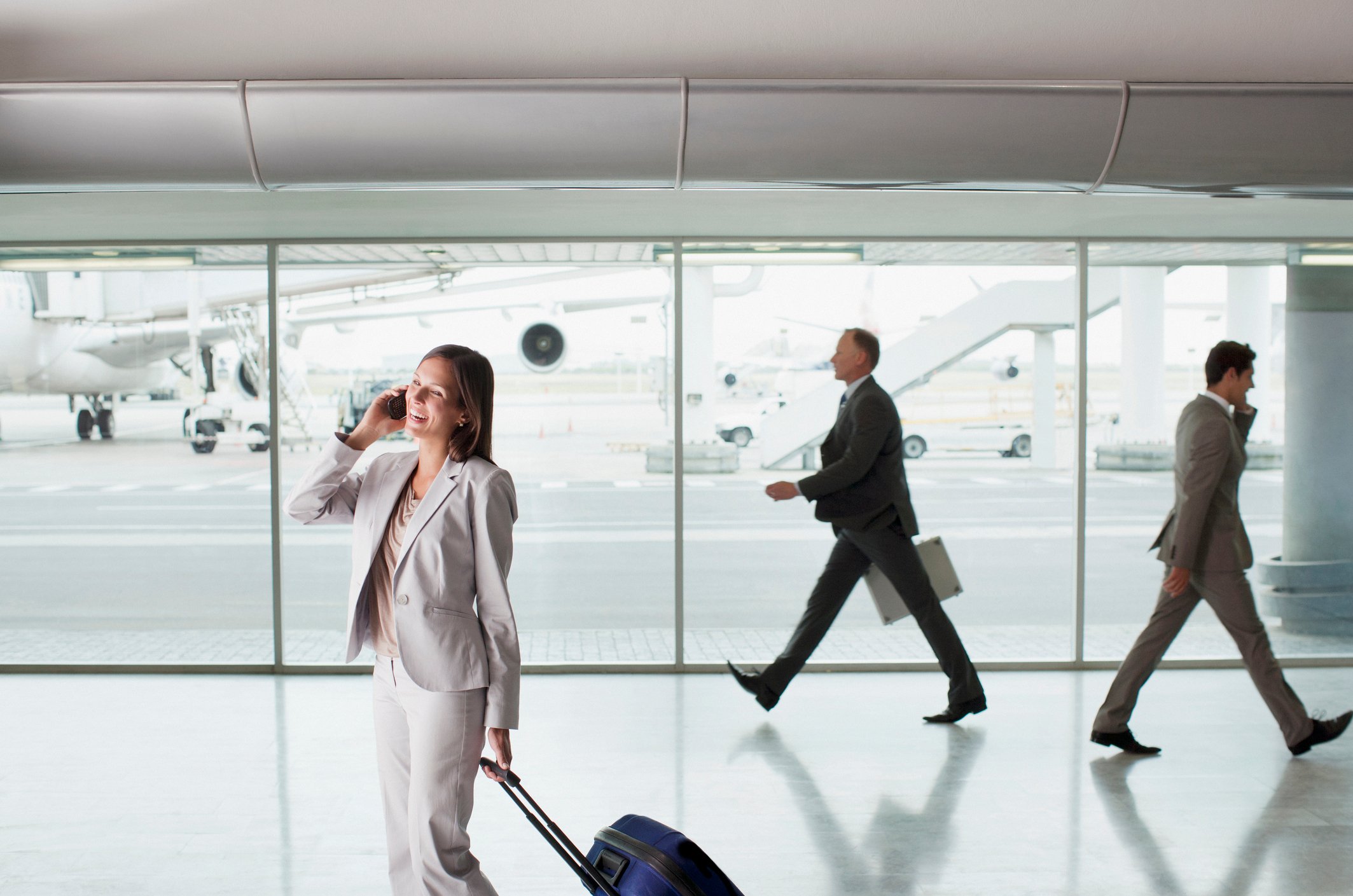 A businesswoman talks on her cell phone in an airport.