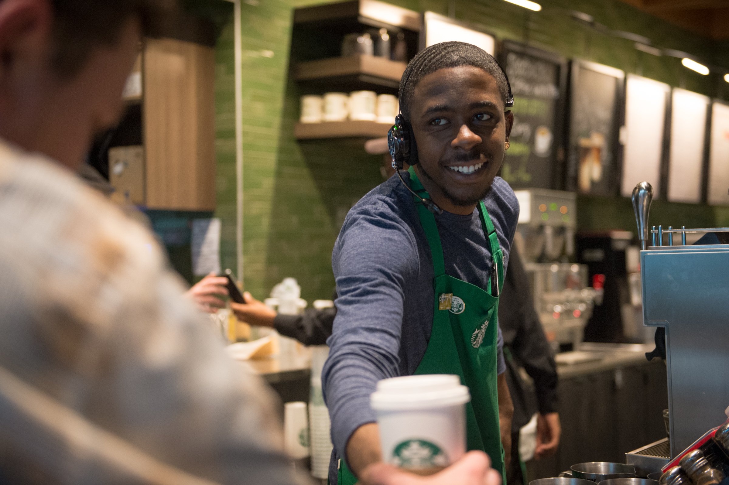 A Starbucks barista serving coffee.