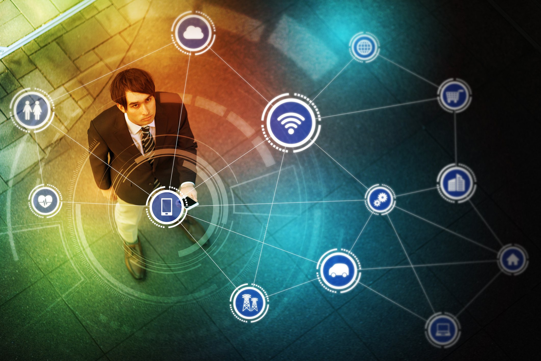 Young man with smartphone, surrounded by graphics to illustrate connected devices in his environment.