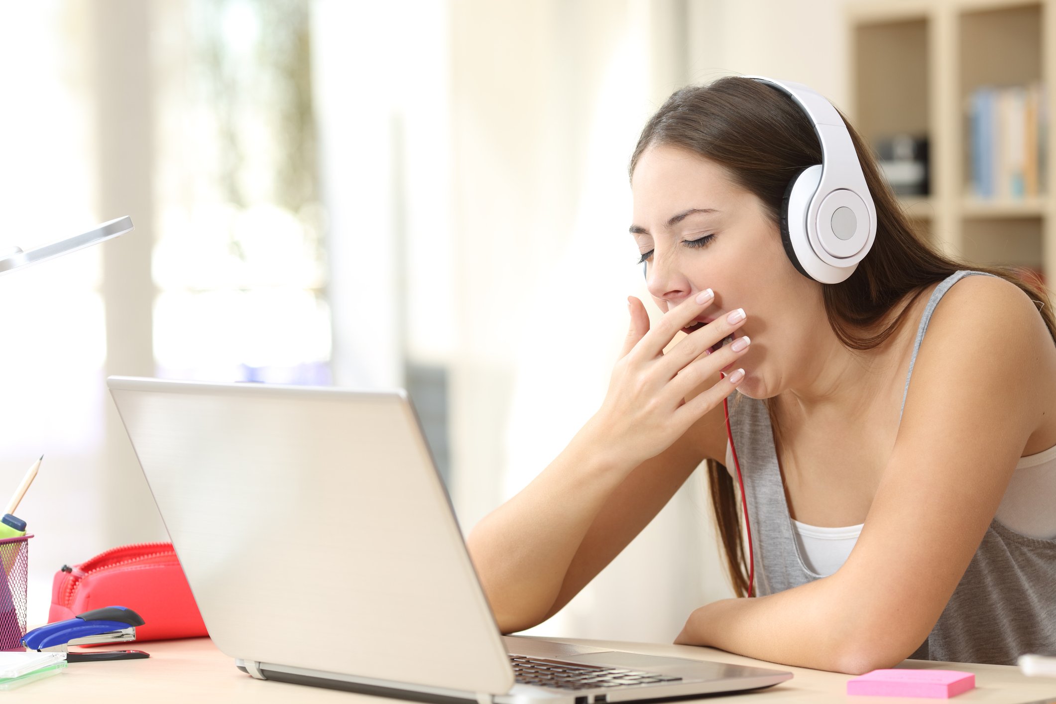 Woman yawning with headphones on.