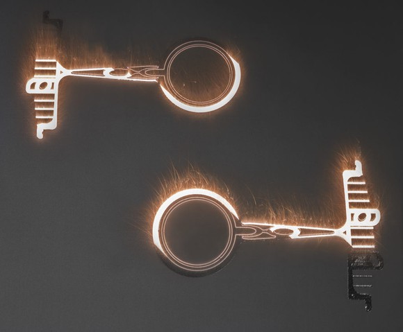 Process showing two metal parts being 3D printed.