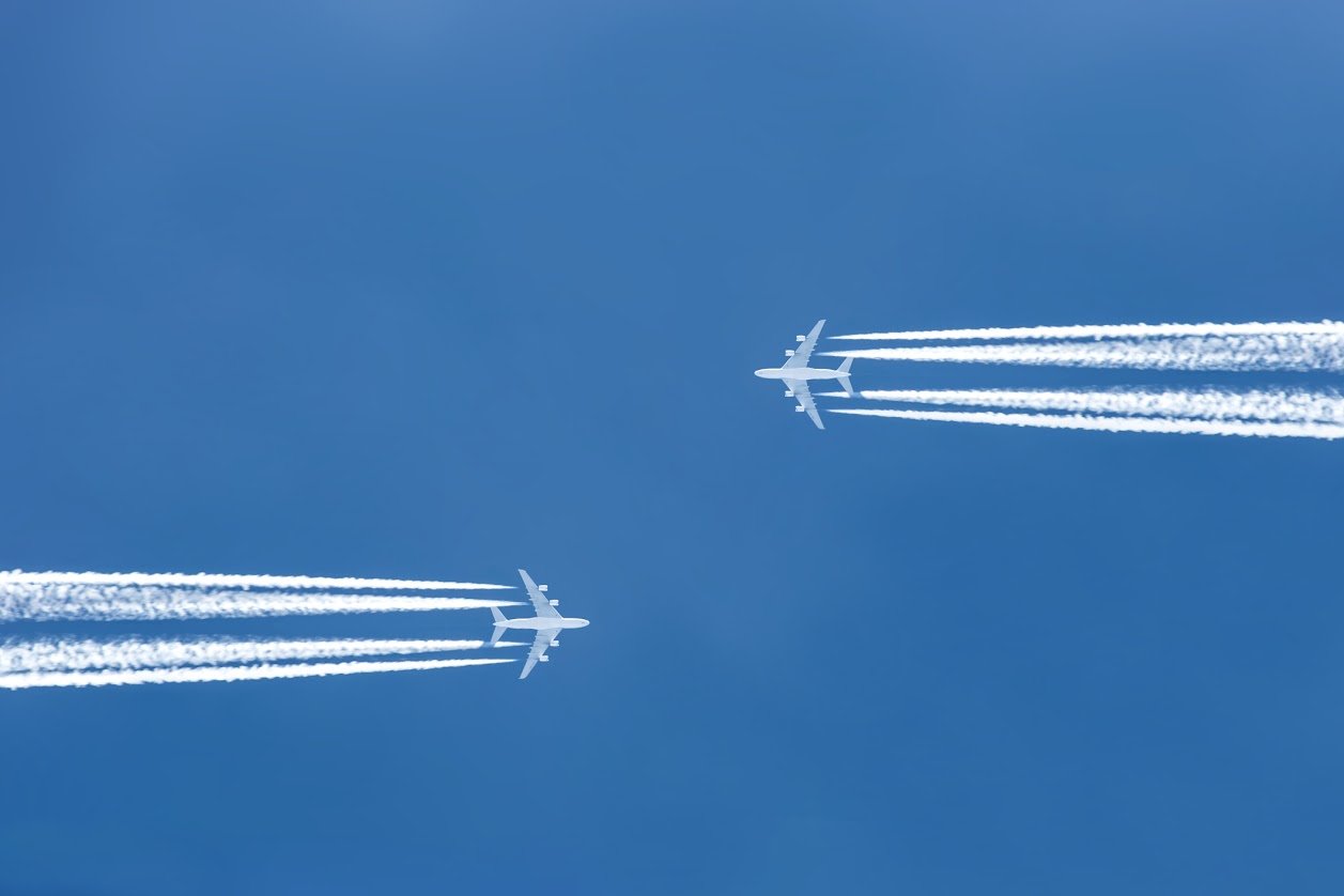Two airplanes flying toward one another 