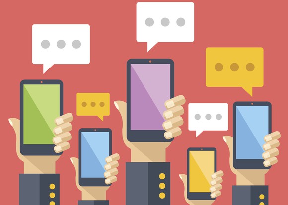 Hands holding up smartphones with message bubbles