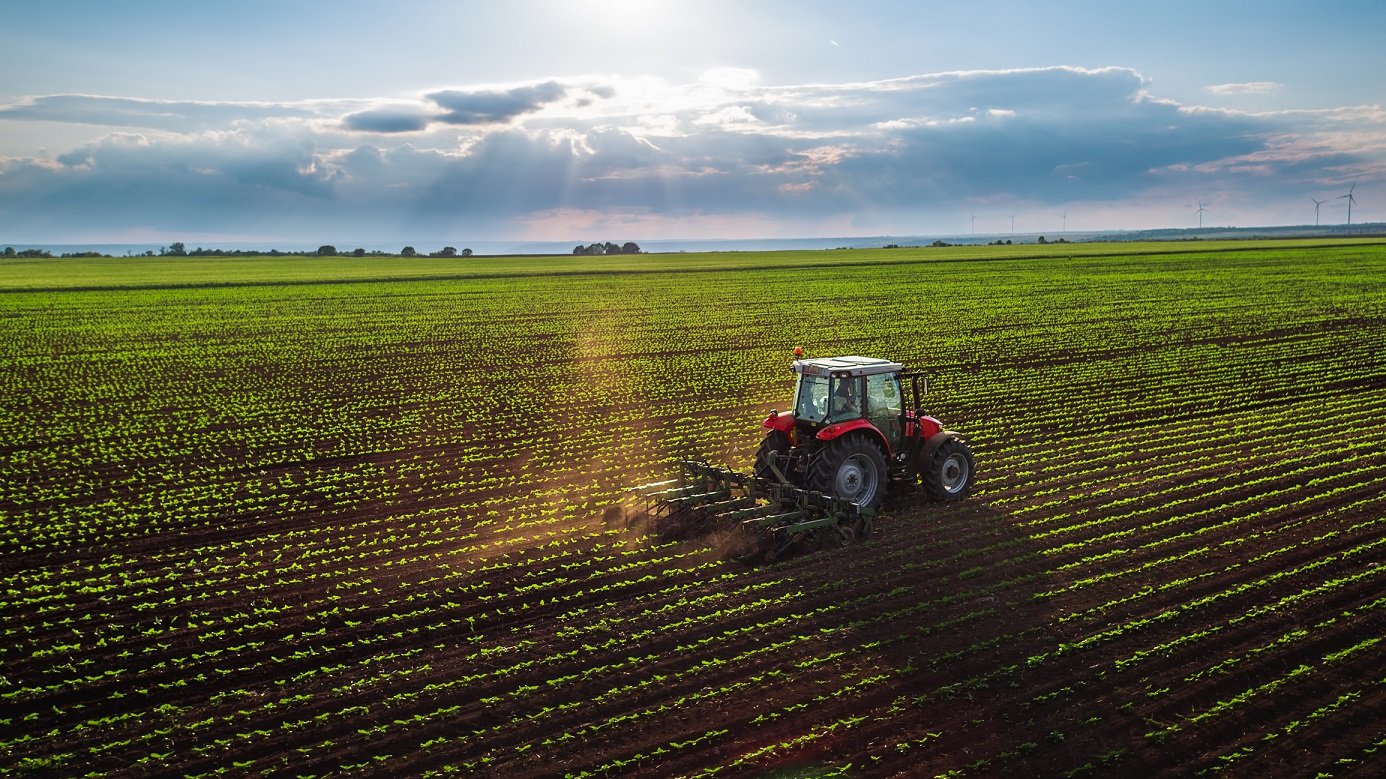 Tractor on a farm in field of crops.
