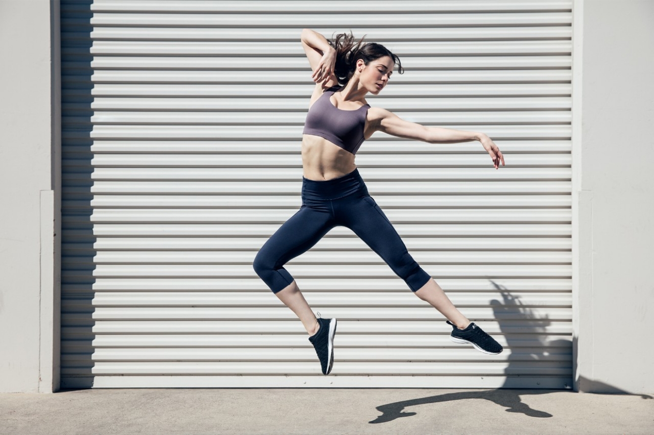 Woman jumping in the air like a ballerina wearing the Lululemon Enlite sports bra.