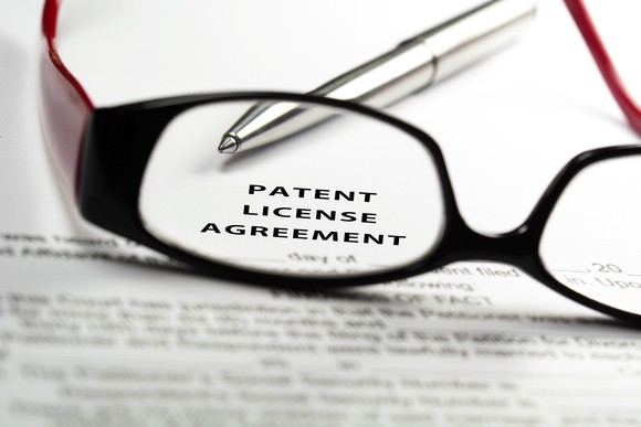 A pair of glasses on top of a patent licensing agreement.