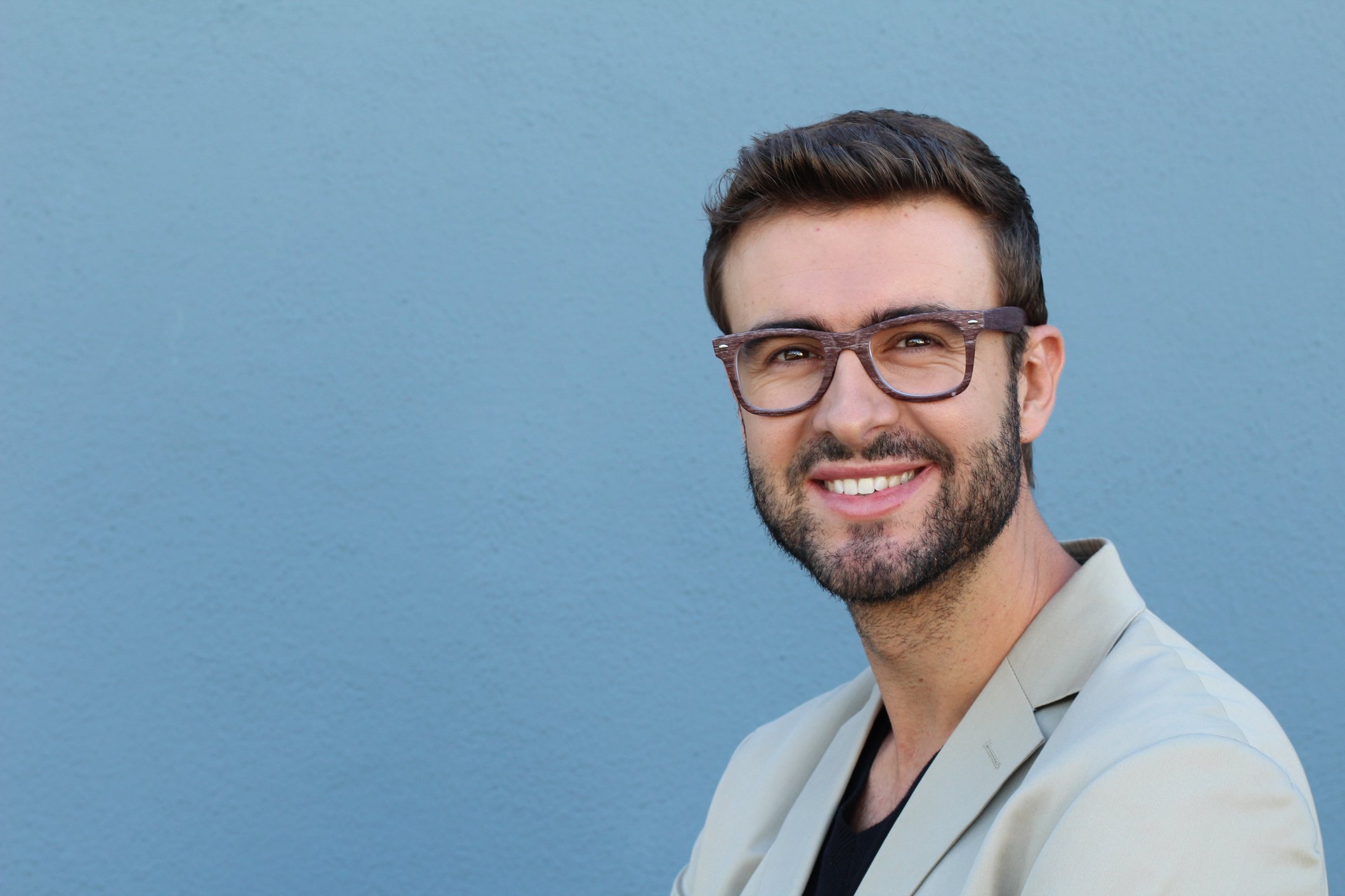 A smiling younger man with glasses and a close-trimmed beard.