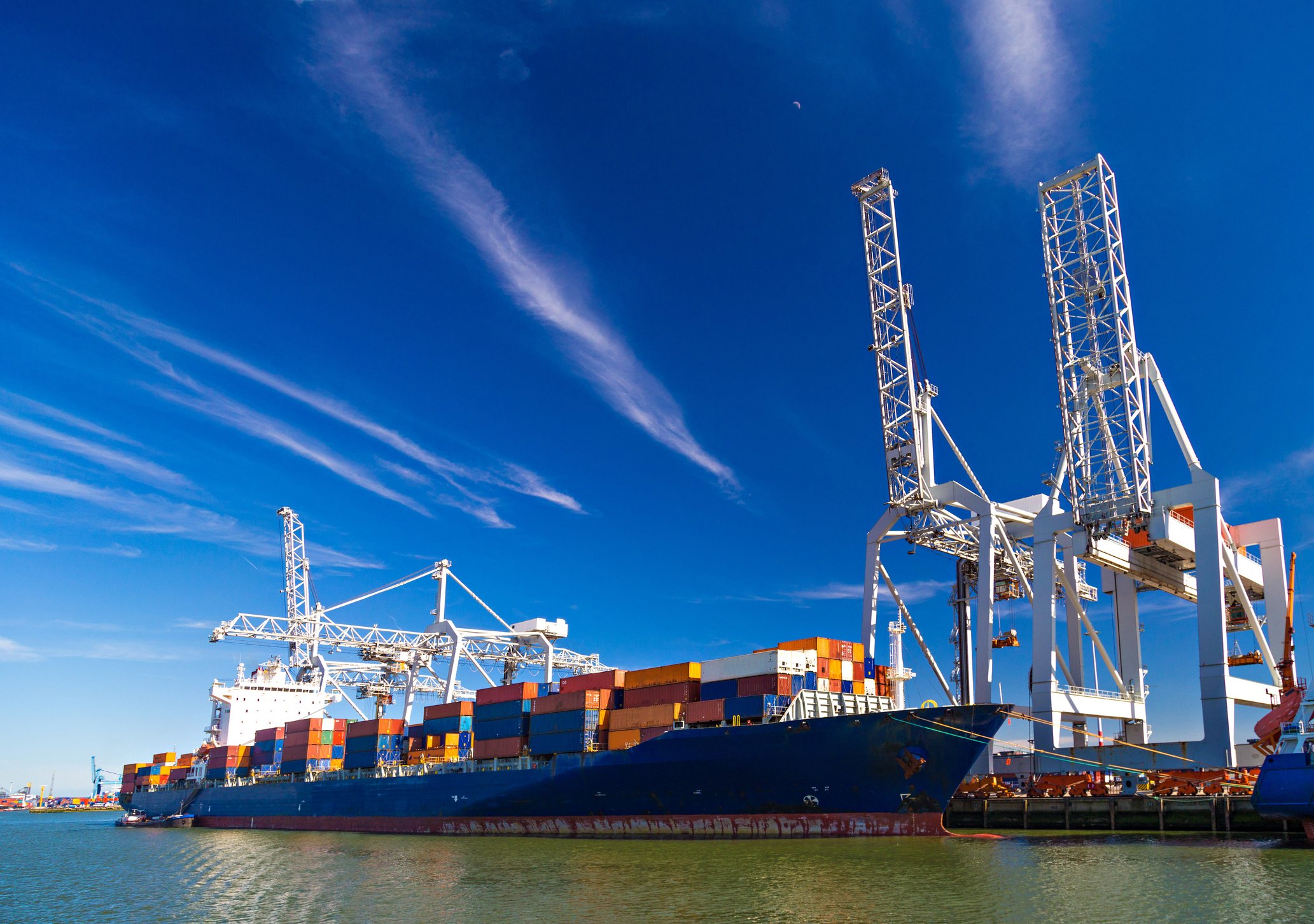 Cargo ship unloading containers in a port.