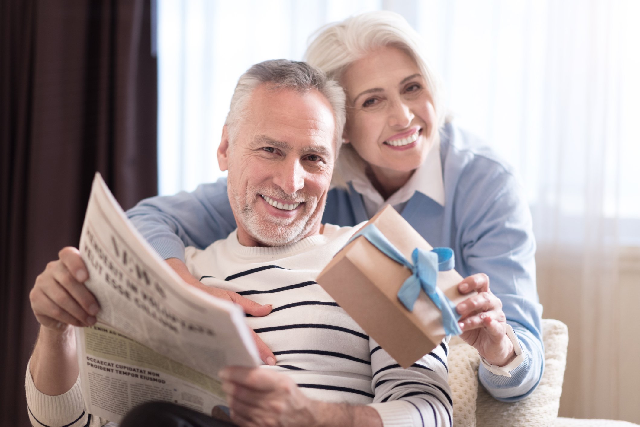 Baby-boomer couple reading the newspaper.