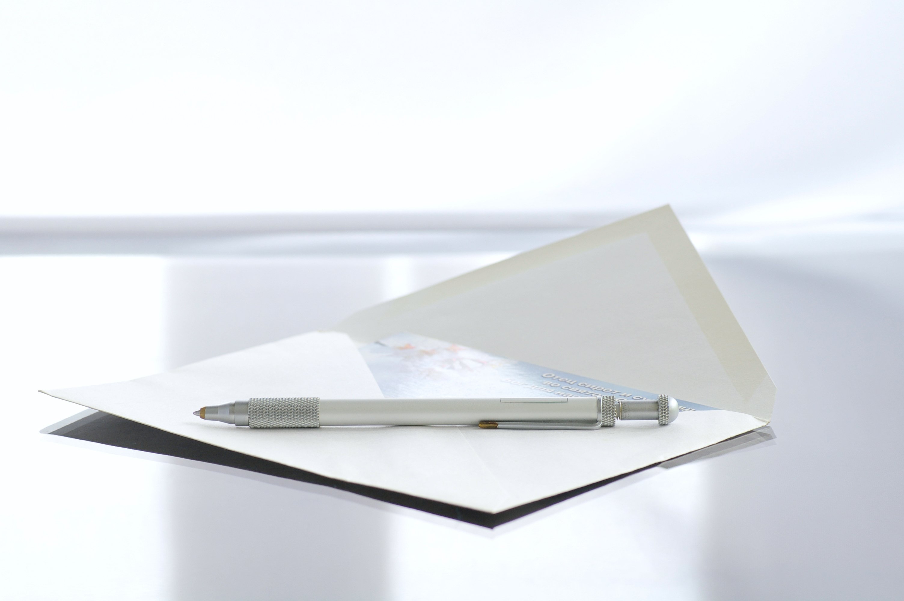 A note cars sits in an envelope with a pent on top of it