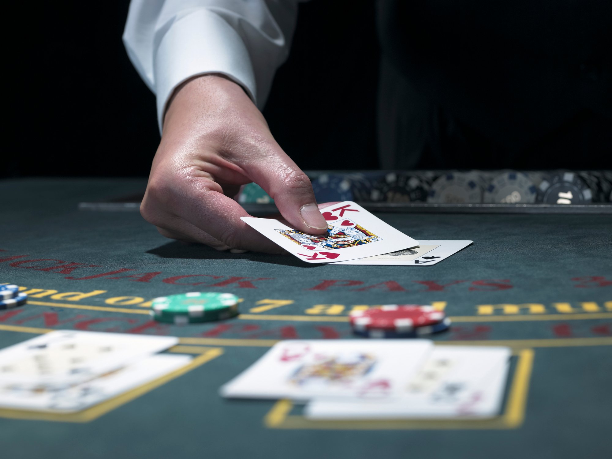 A blackjack dealer puts cards on the table.