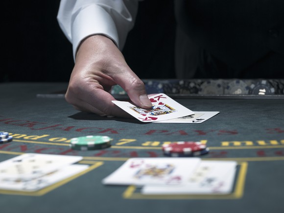 A blackjack dealer puts cards on the table.