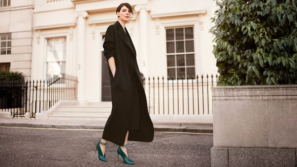 Woman modeling green high-heel shoes.
