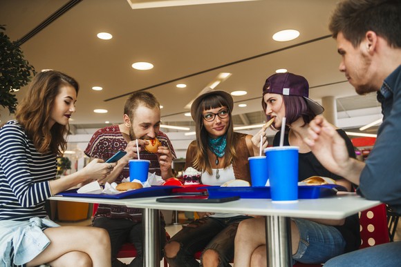 Friends eating fast food in a mall.