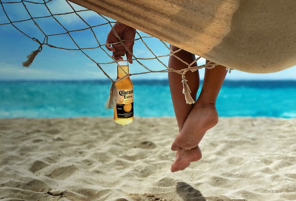 Person in a hammock holding a Corona