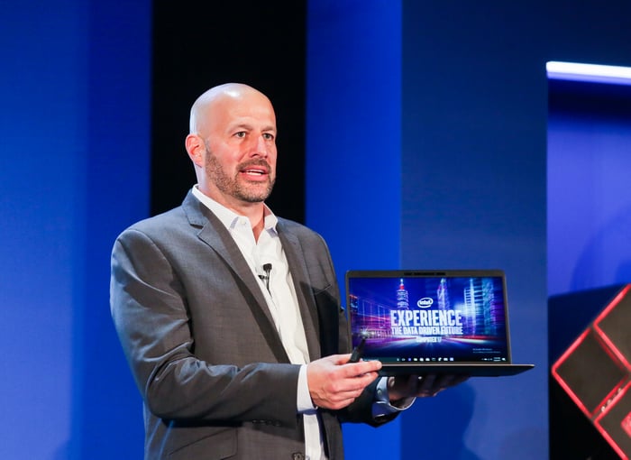 Intel executive Gregory Bryant holding a laptop.