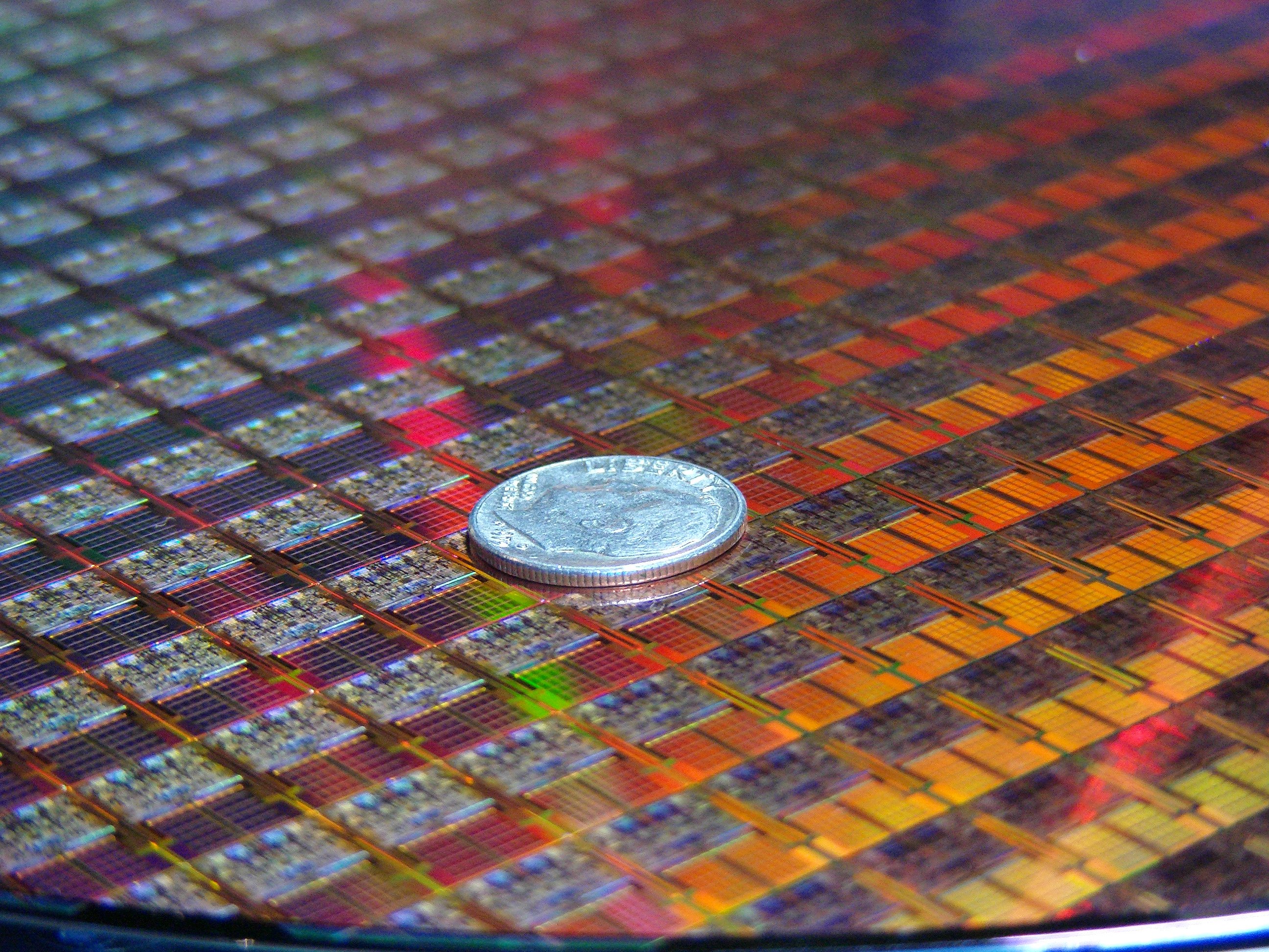 An Intel silicon wafer with a coin on top of it.