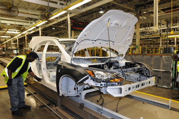 A worker inspects a partially-assembled Ford Focus on the production line at Ford's Michigan Assembly Plant in Wayne, MI.