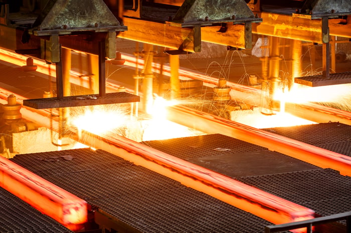 Hot steel on conveyor in steel mill.