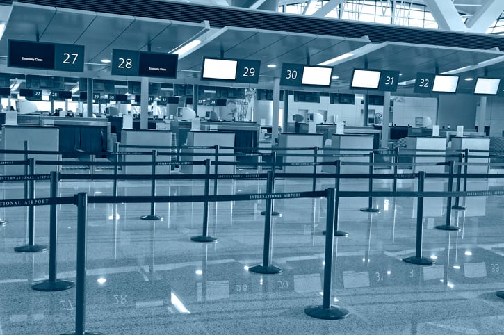 Empty airport ticket counters in greyscale