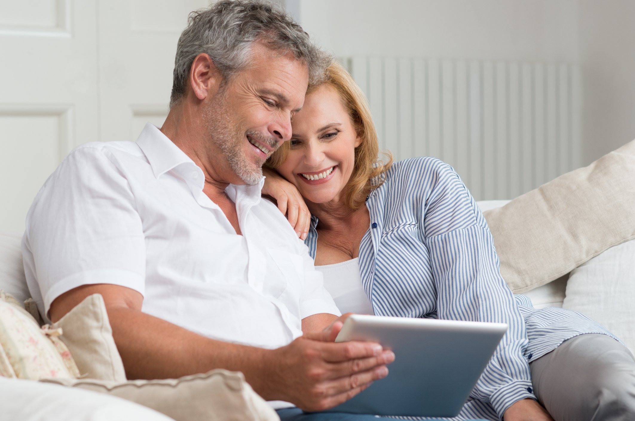 50-something couple looking at a tablet.