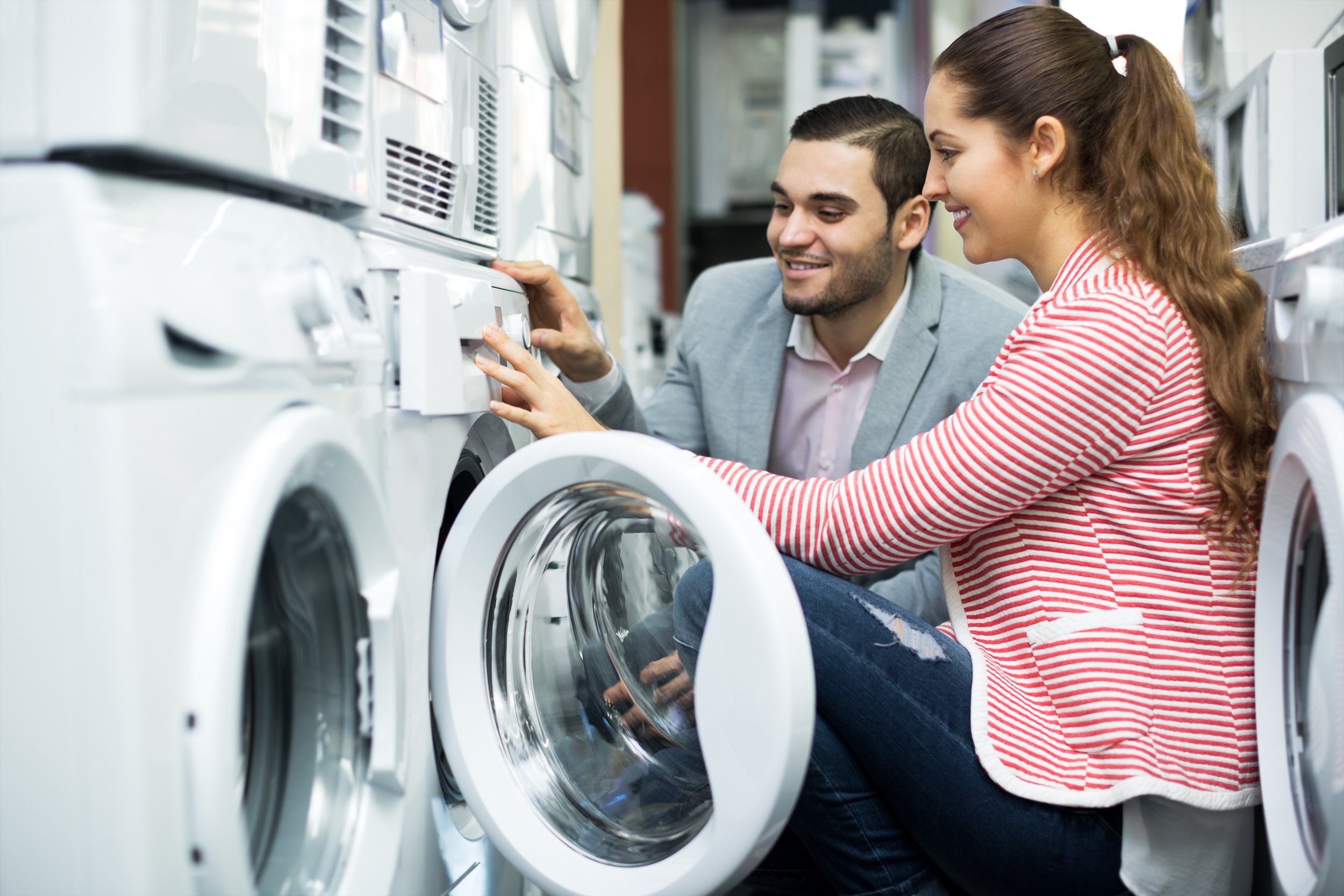 A woman and a man kneel near a dryer