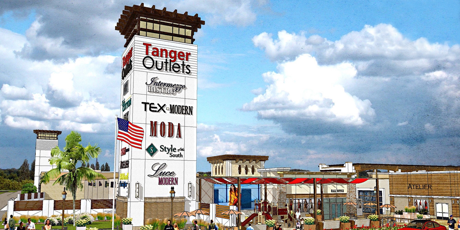 A Tanger Outlet's mall with a large tower sign