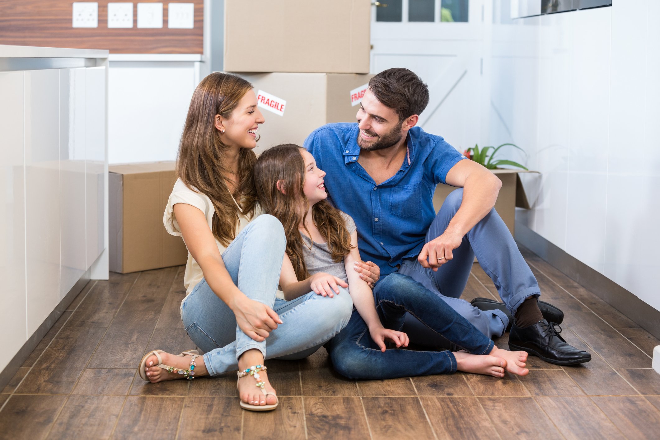 Family sitting on new laminate flooring