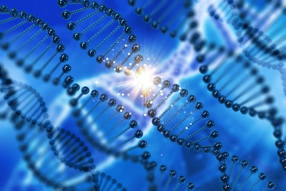 DNA strands on blue background with spark of light at center of one DNA strand