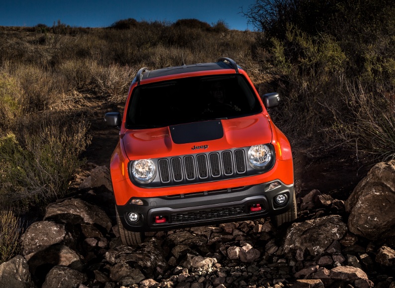 A red Jeep Renegade driving offroad