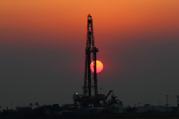A drilling rig with the setting sun in the background.