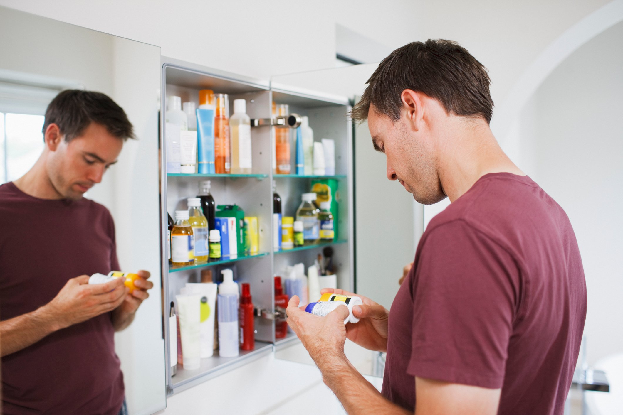 Man looking at medicine in cabinet