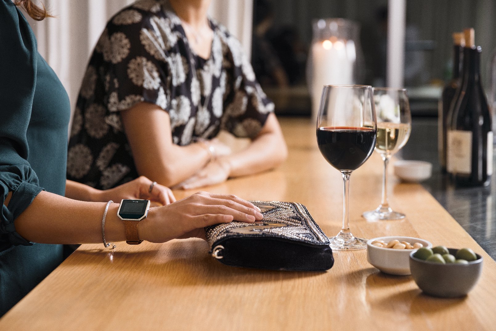 Woman wearing a Fitbit Blaze and drinking wine