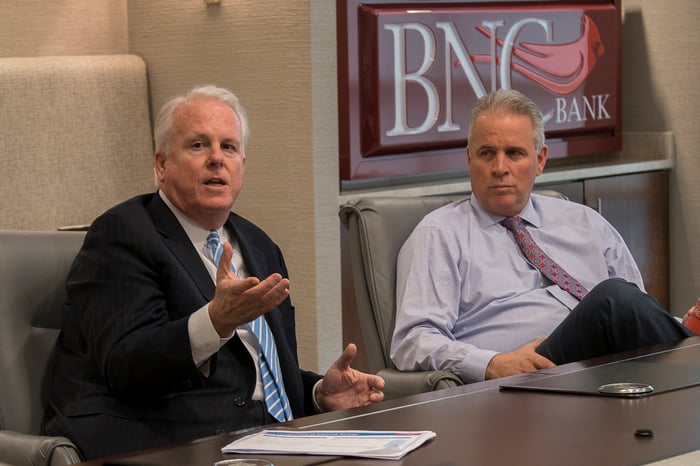 The CEOs of Pinnacle Financial Partners and BNC Bancorp sitting at a conference table.