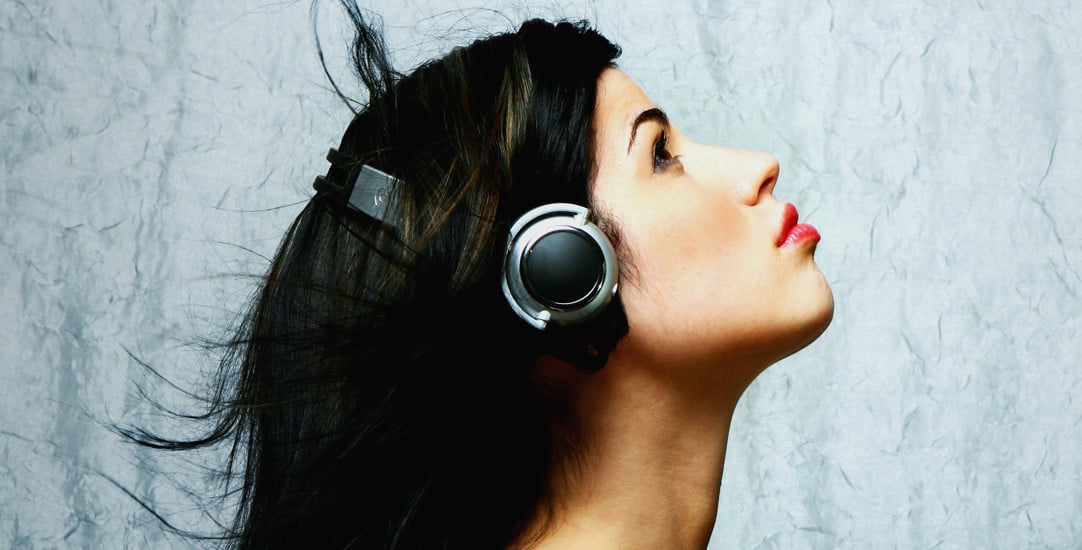 A woman in profile wearing headphones