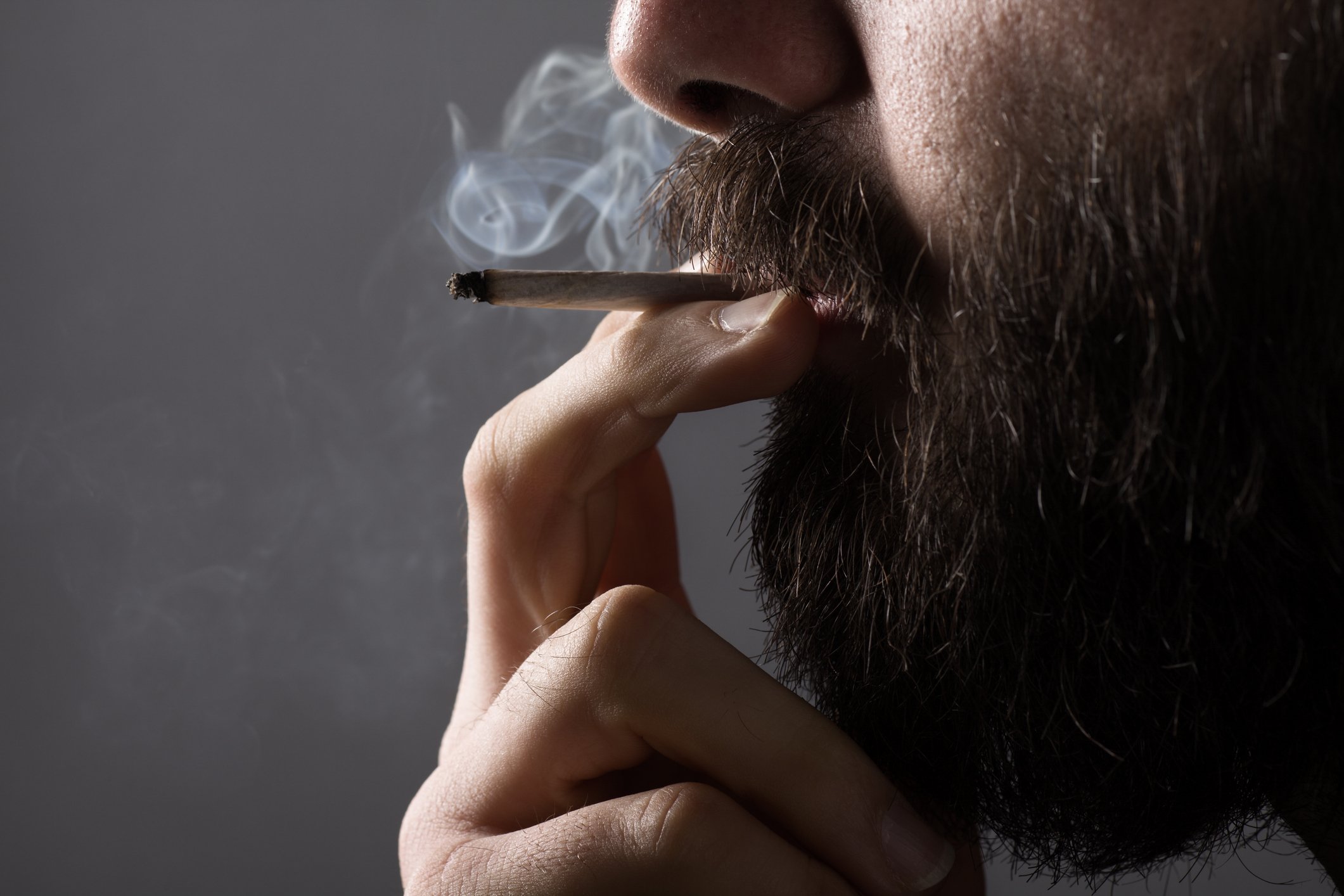 A bearded man smoking a cigarette