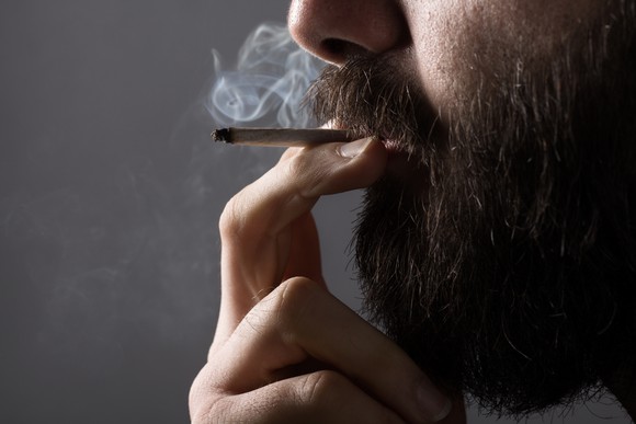 A bearded man smoking a cigarette
