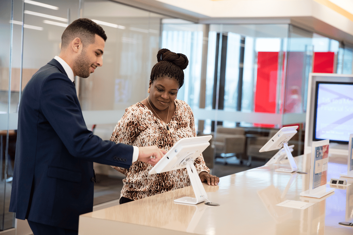 A Bank of America associate helps a customer navigate a mobile device.