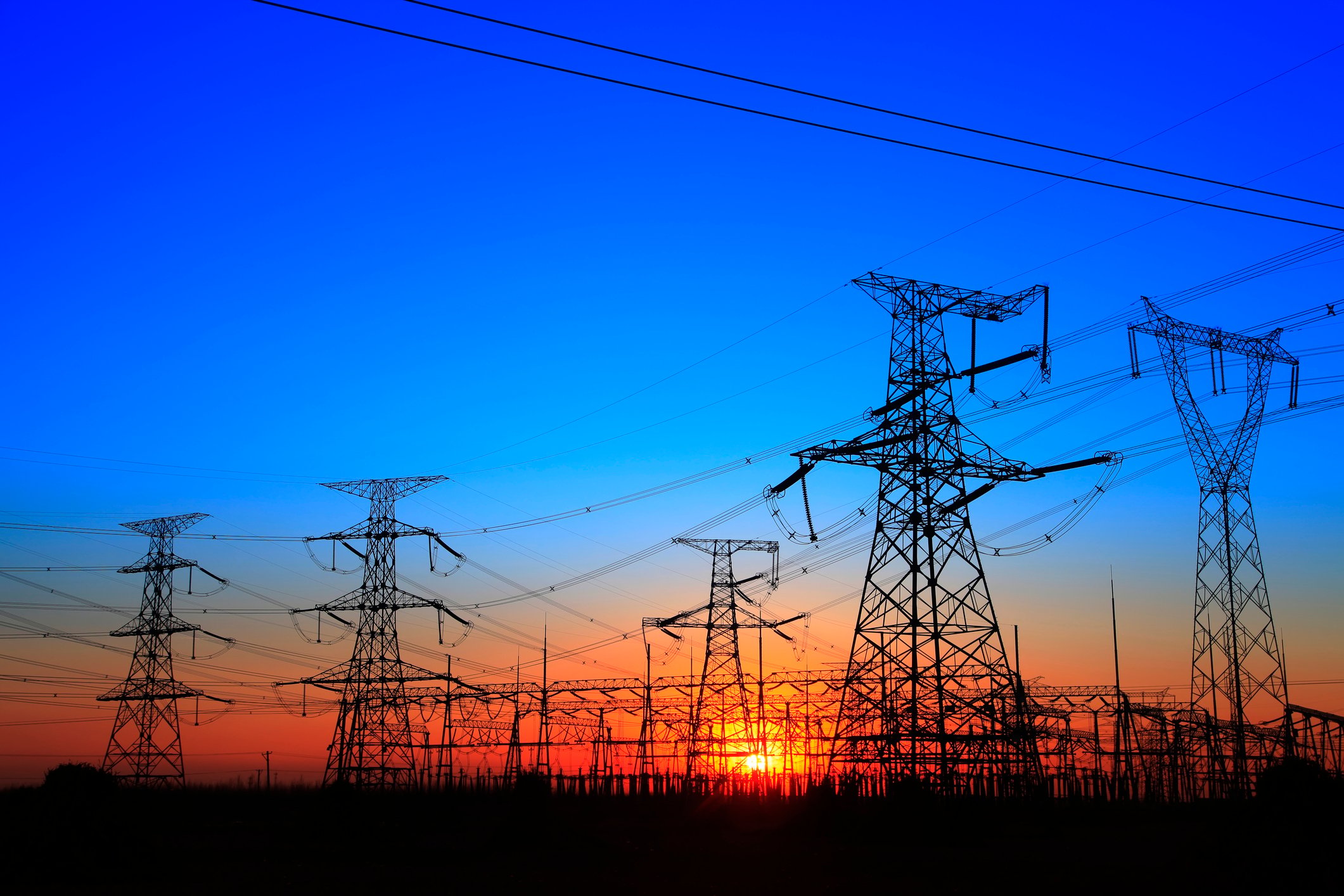 Power transmission line towers at sunset.