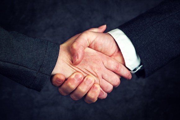 Two businessmen in suits shaking hands