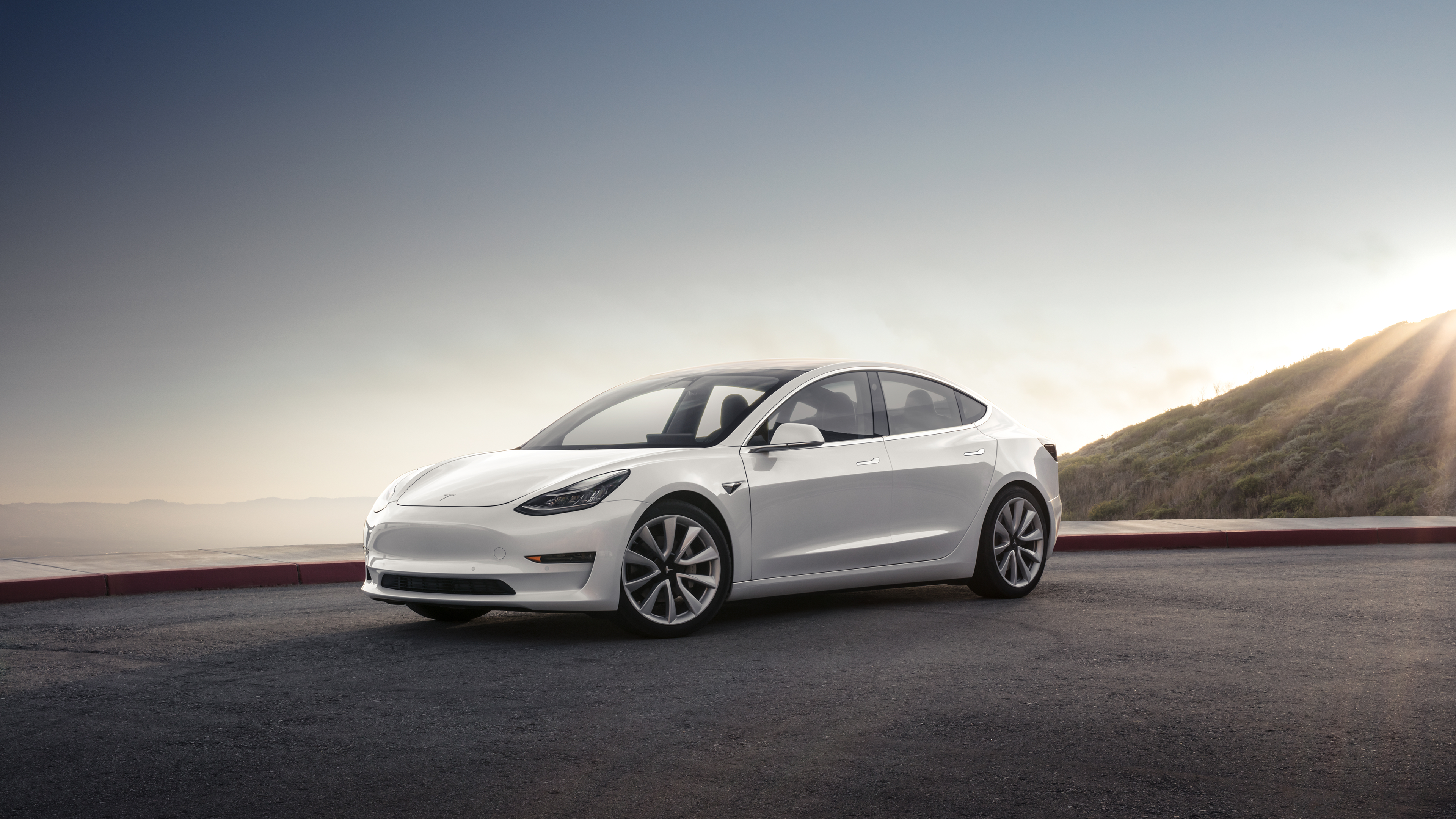 White Model 3 in front of a mountain