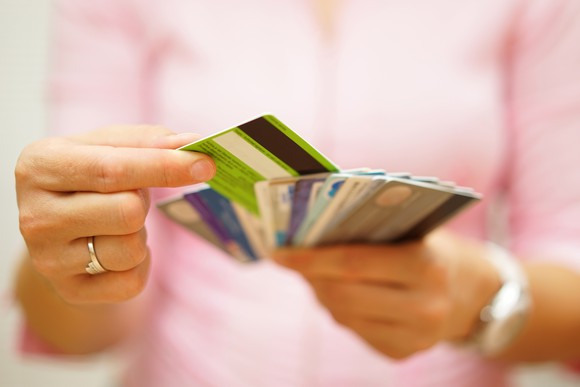 A woman picking a credit card from among many.