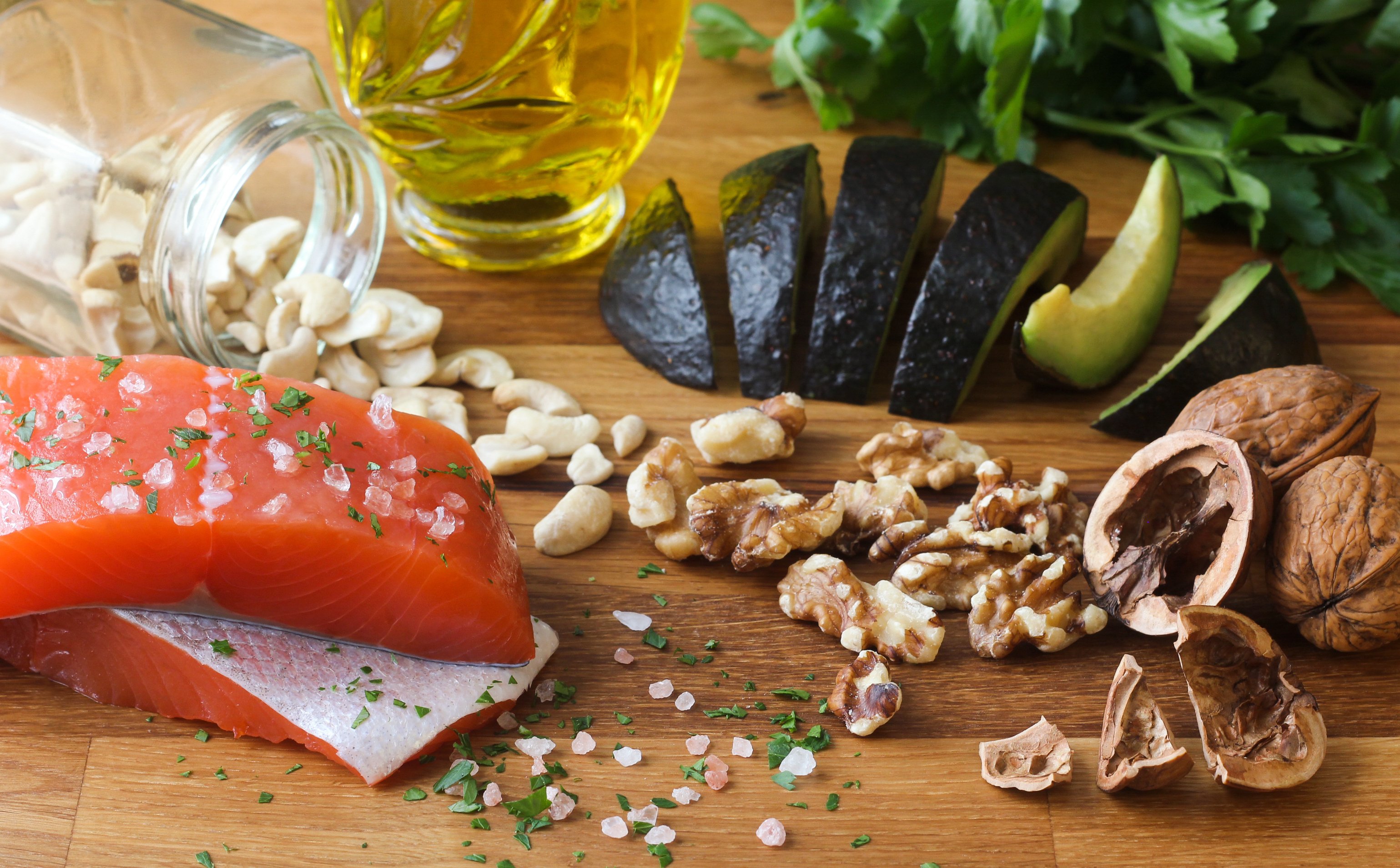 Fresh fish and food laid out on a wooden cutting board
