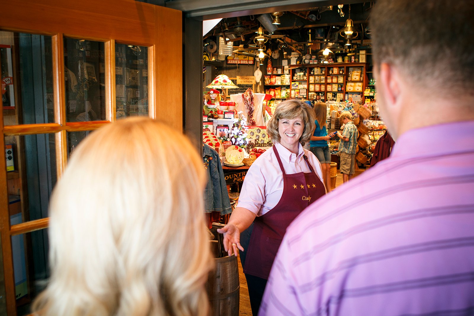 A woman greeting customers into a Cracker Barrel location.