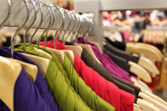 A rack of colorful dresses at a clothing store