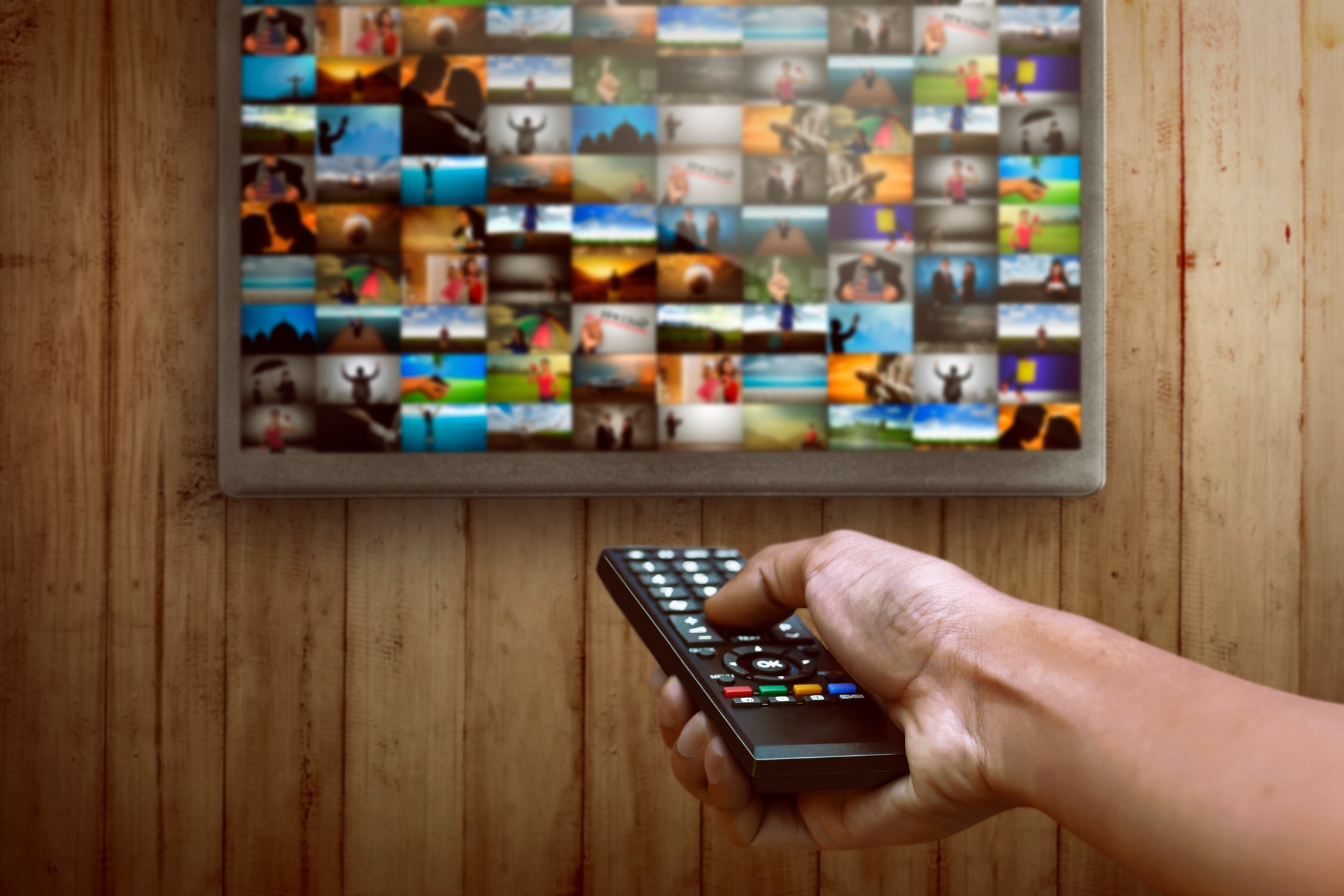 Person choosing channel on the television with remote.