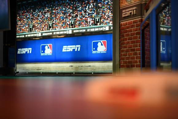 The set in an ESPN studio showing an image of an ESPN ad on a banner at a baseball game.