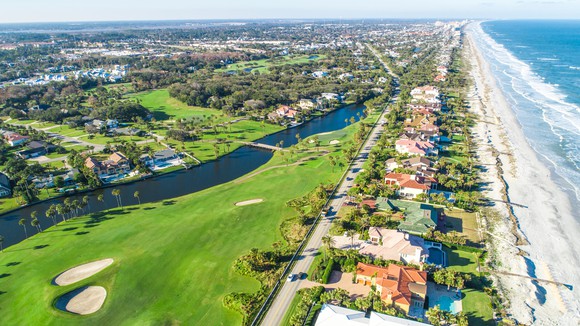 Aerial view of neighborhood between a beach and a golf course