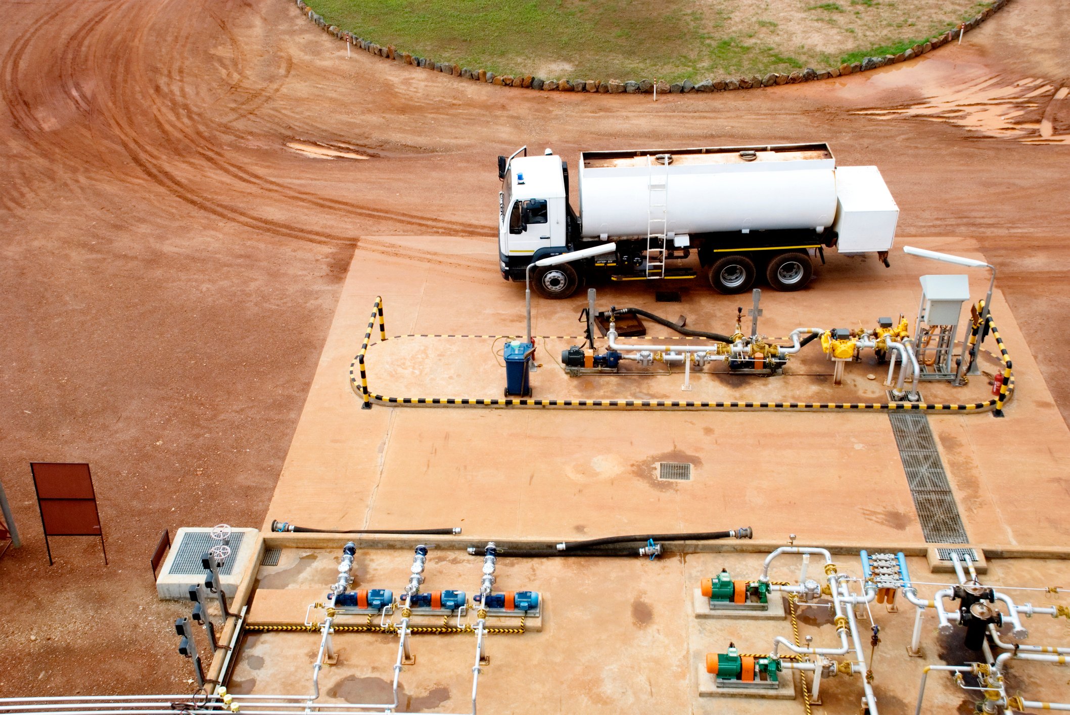 A natural gas truck filling up at an industrial refueling station.