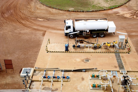 A natural gas truck filling up at an industrial refueling station.